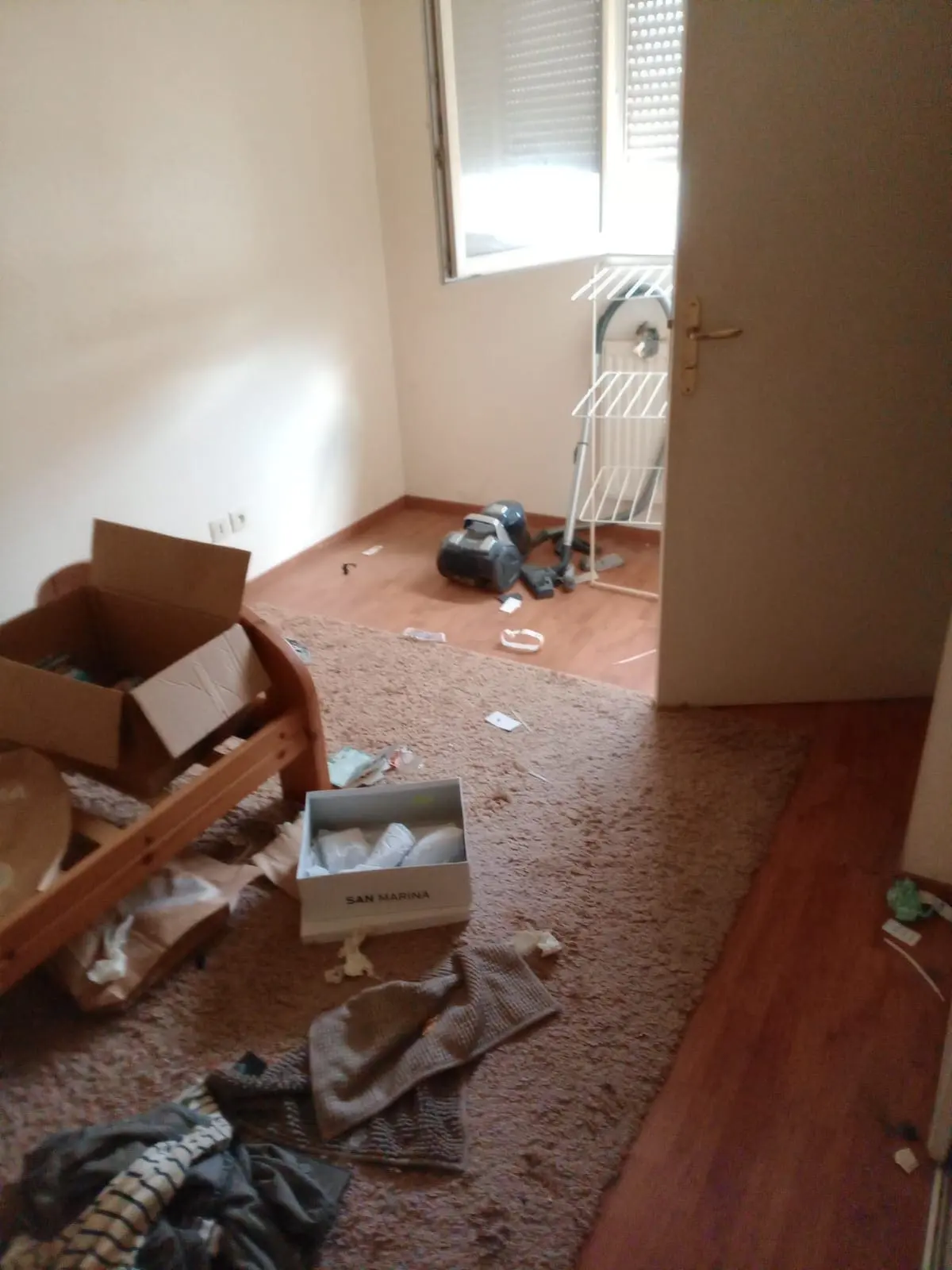 Chambre encombrée de cartons et de textiles avant débarras
